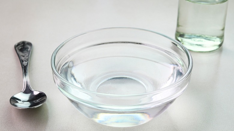 Vinegar in glass bowl with spoon nearby