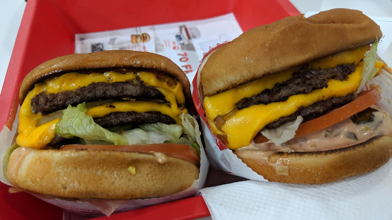 Two animal style burgers at In-N-Out sitting on a tray.