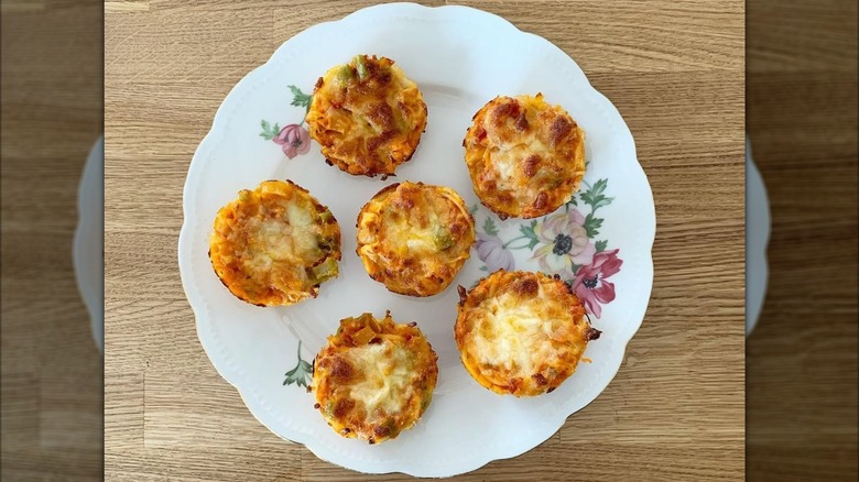 Top view of baked pasta cupcakes on white floral plate