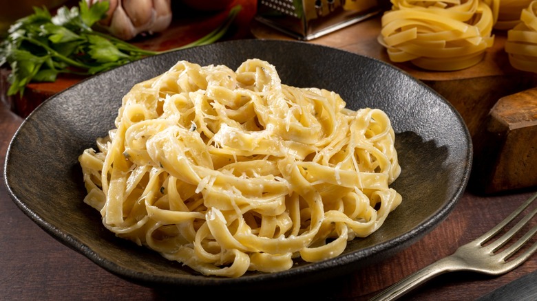 Fettuccine Alfredo pasta in dark bowl