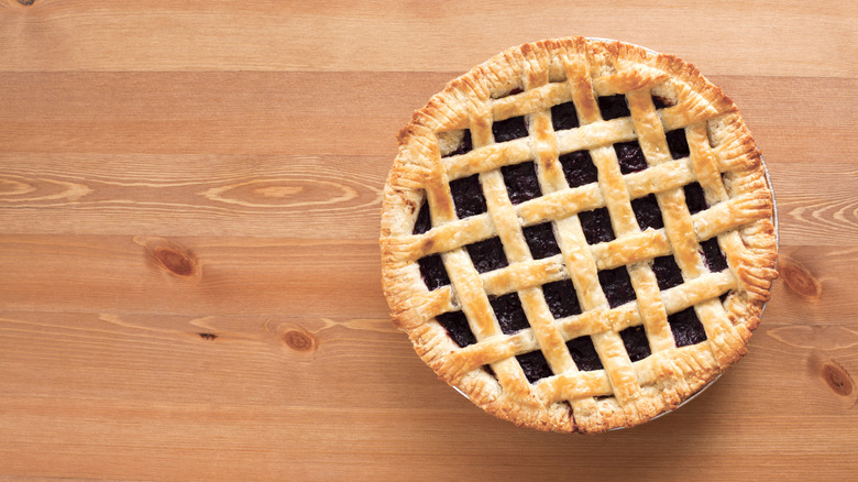 Overhead view of a blueberry pie on a wooden table
