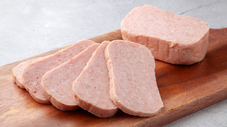 Sliced spam on a wooden cutting board