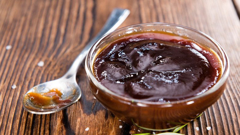 Barbecue sauce served in a small bowl and a spoon on the side.