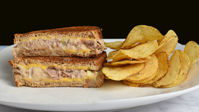 A tuna melt sandwich with a side of potato chips