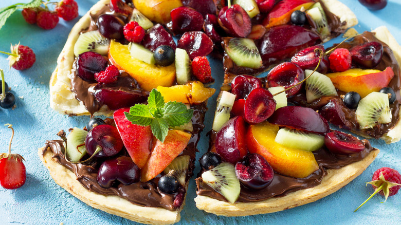 Pizza crust topped with fruit and chocolate sauce
