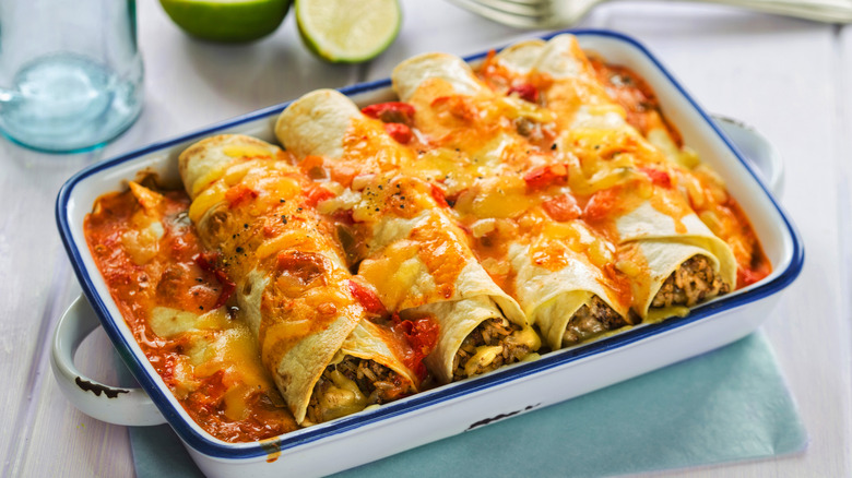 Beef enchiladas in a dish with red sauce and cheese