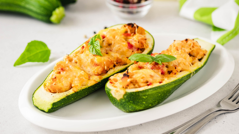 Enchilada-stuffed zucchini boats on a white plate