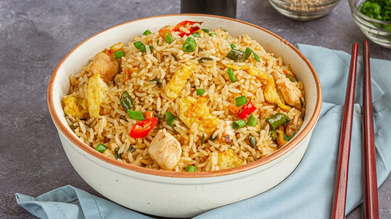 A bowl of fried rice with chopsticks