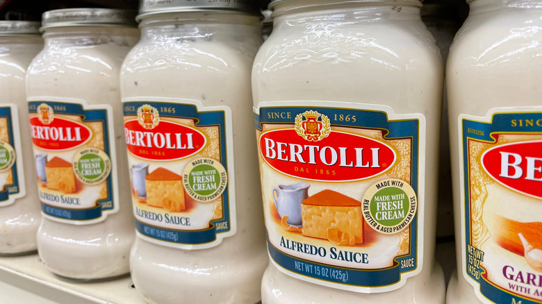 Multiple jars of Bertolli Alfredo sauce on the shelf