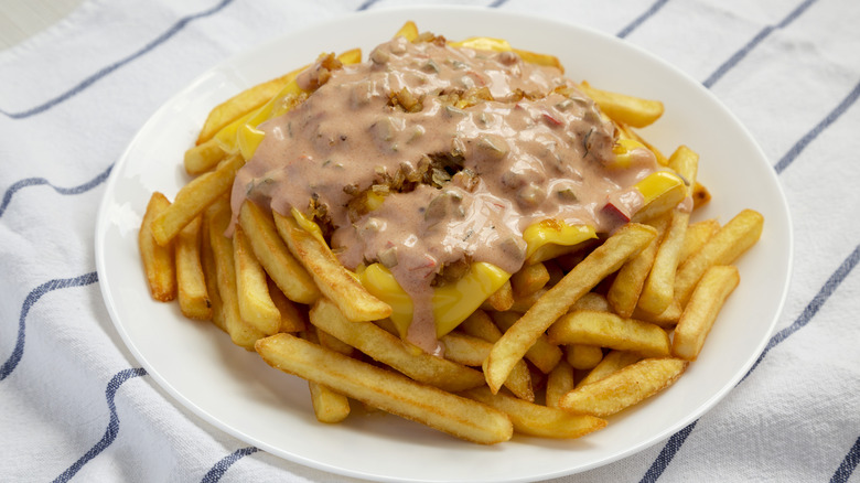 homemade Animal Style Fries on a plate with the sauce and cheese on top