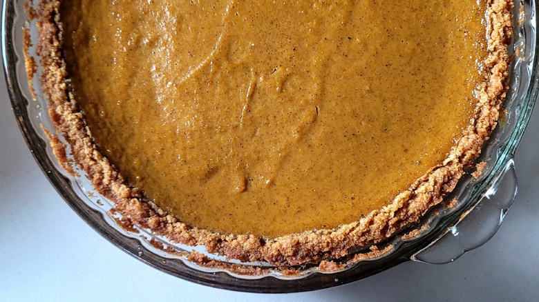 A closeup of pumpkin pie in a graham cracker crust