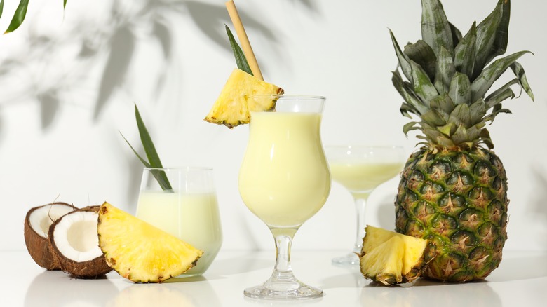 Pina colada in cocktail glass garnished with pineapple wedge.