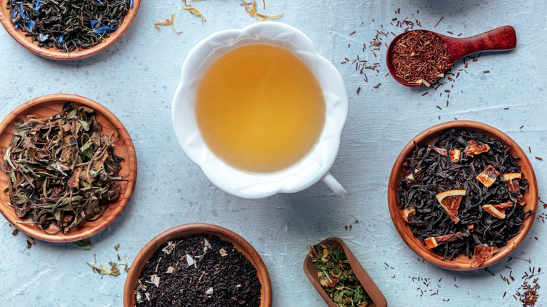 Loose-leaf teas in wooden ramekins with a cup of tea