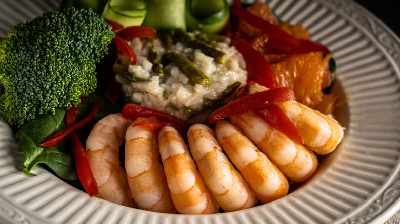 Shrimp on a plate with risotto, broccoli, and peppers