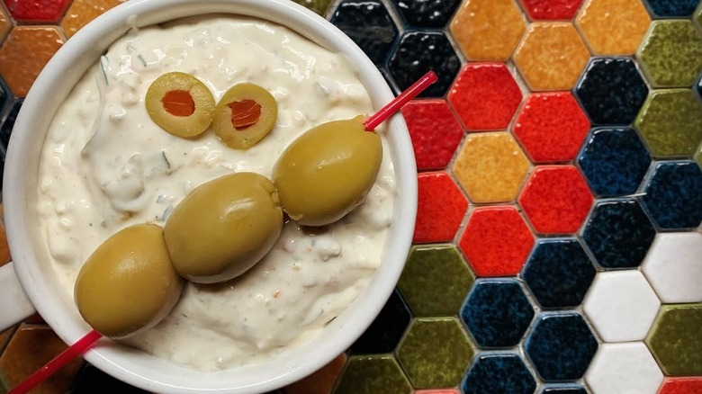dirty martini-flavored dip garnished with olives