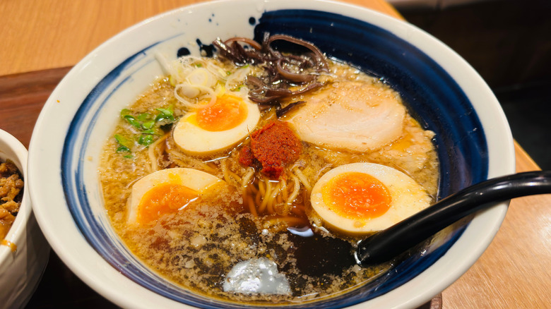 A bowl of ramen with eggs and other toppings