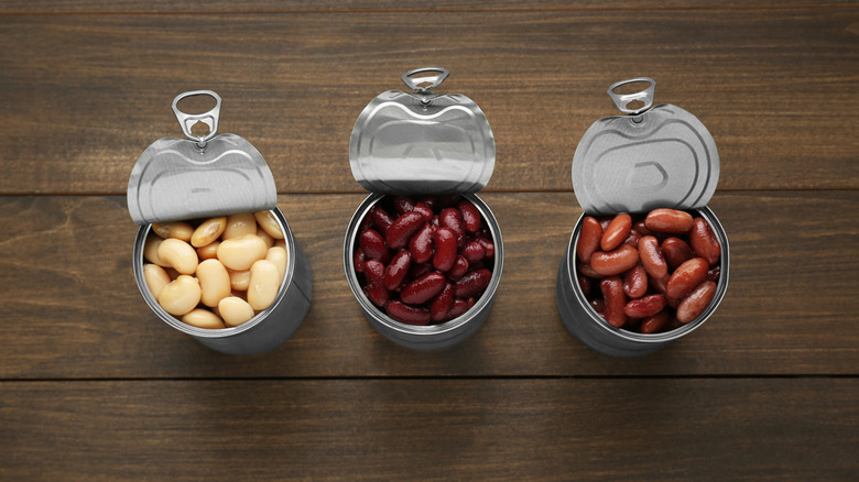 Three different kinds of canned beans in open cans