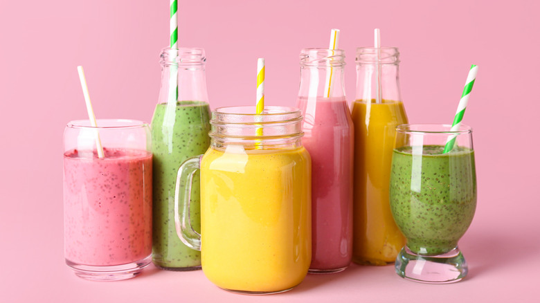 different types of fruit smoothes on pink background