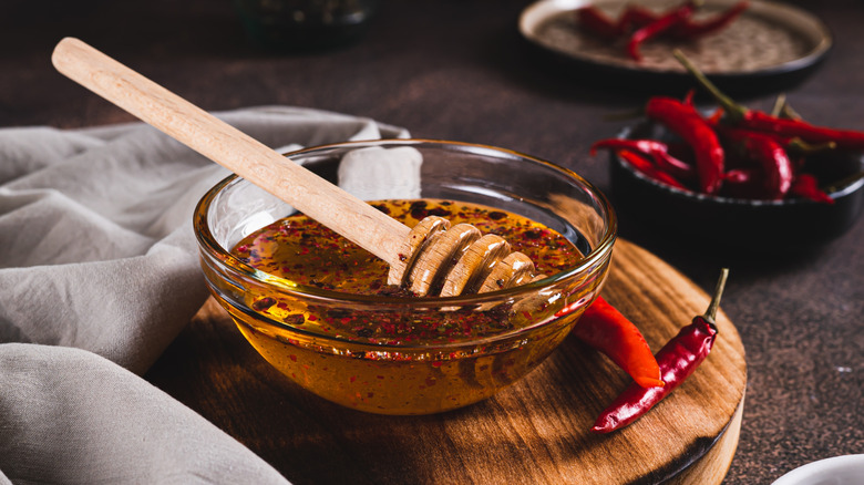 Hot honey sauce in glass bowl with chile peppers
