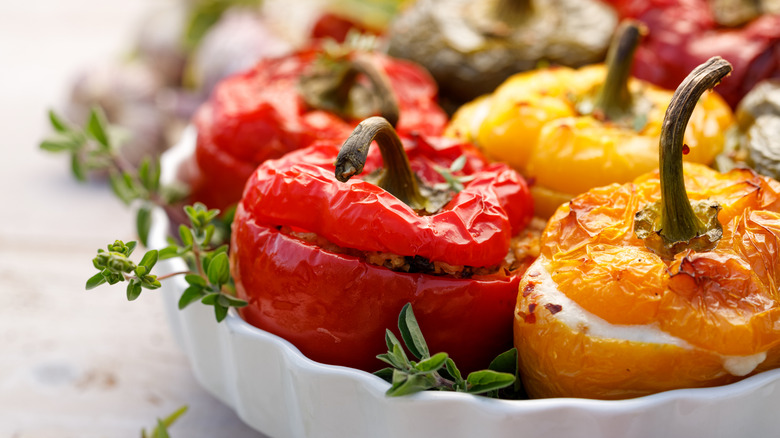 Stuffed peppers in yellow and red on a white dish