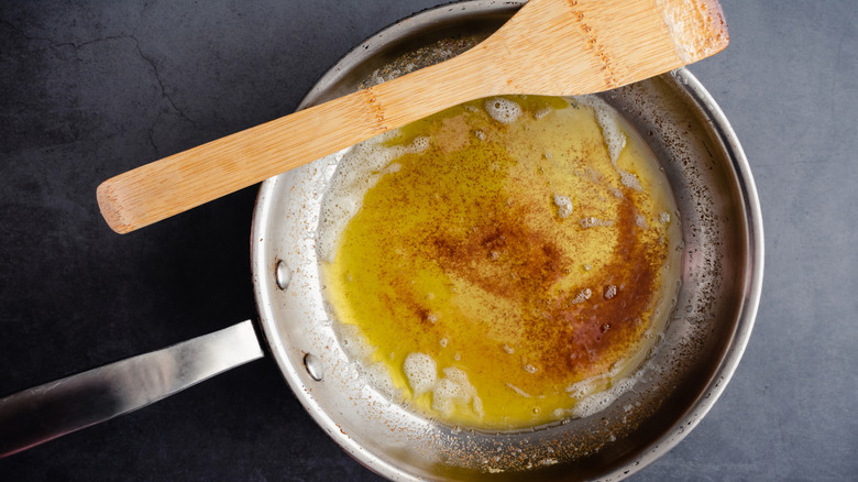 Browned butter in a frying pan with a wooden spatula