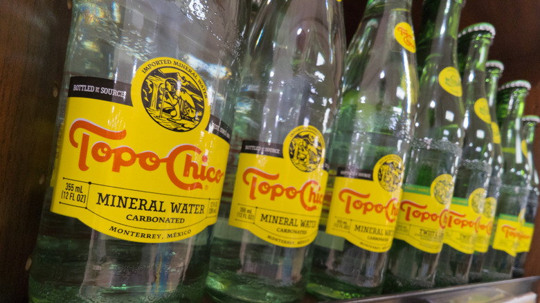 Bottles of Topo Chico carbonated mineral water on a store shelf
