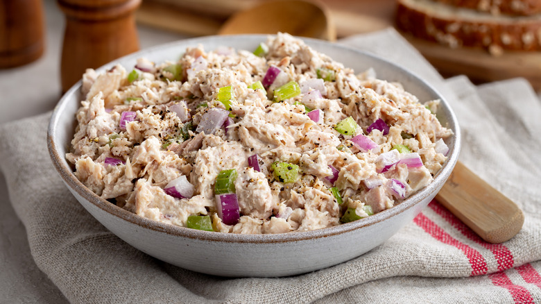 Tuna salad with red onions and celery in a white bowl