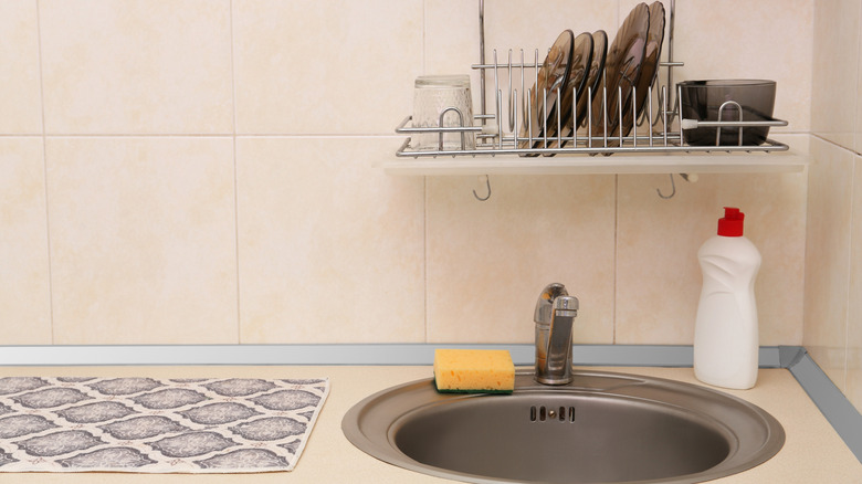 An over-the-sink drying rack with plates hanging over the sink