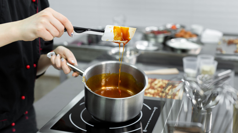A cook making caramel in a pot.
