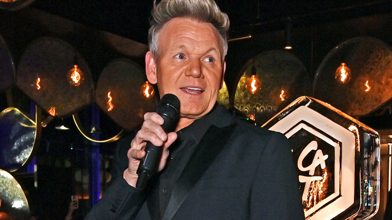 Gordon Ramsay in black suit with microphone