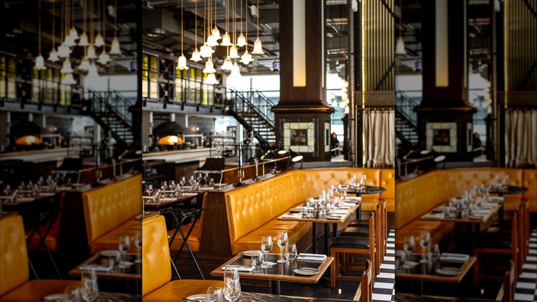 Elegant and spacious interior with booths, wine glasses, and hanging lights inside Bread Street Kitchen St. Paul's in London