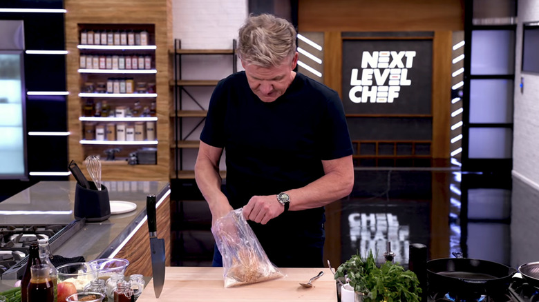 Gordon Ramsay preparing pork chop in the kitchen using his nifty coating method.