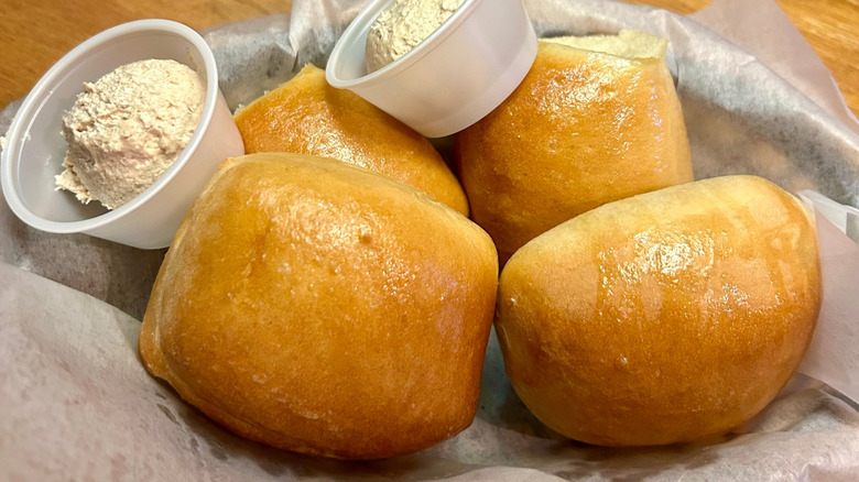 Texas Roadhouse rolls in basket with honey cinnamon butter.