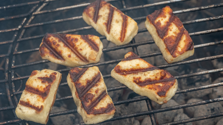 Slices of halloumi cheese with char marks on a hot grill
