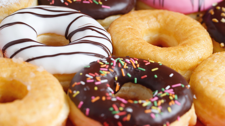 Assorted donuts including glazed, chocolate sprinkles, and white frosted