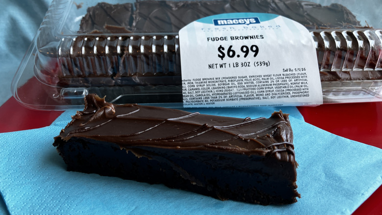 A long and thin piece of chocolate frosted brownie is displayed with the package of the rest of the brownies in the background.