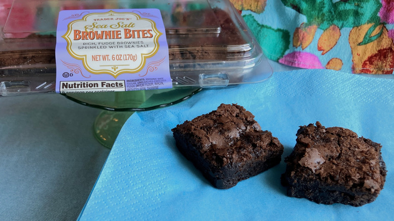 Two brownies on a blue napkin with the Trader Joe's packaging the background.