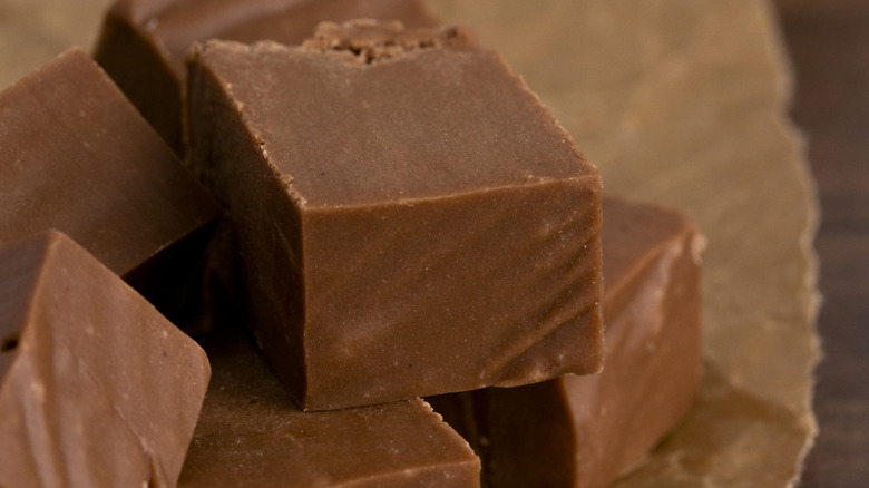 Chocolate fudge dessert cubed on a wooden counter