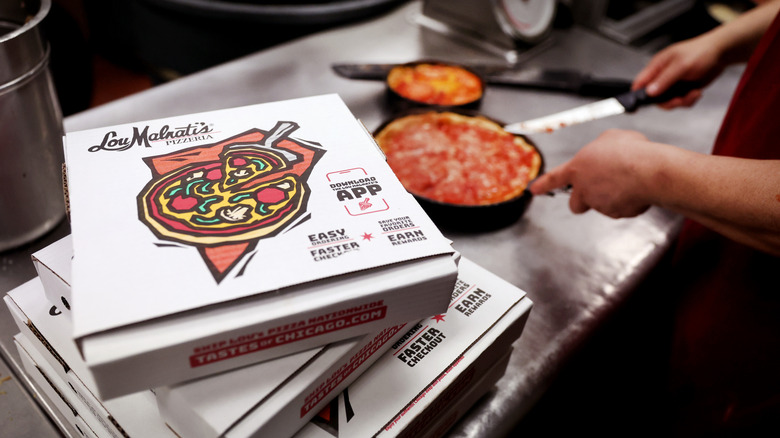 Lou Malnati's worker prepares a deep-dish pizza