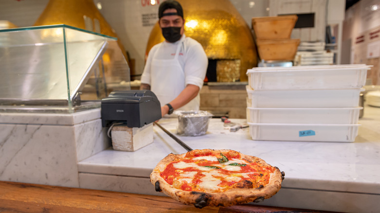 A New York Neapolitan pizza topped with mozzarella cheese and fresh basil