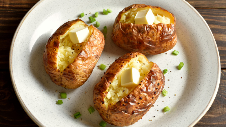 Baked potatoes split open with cubes of butter