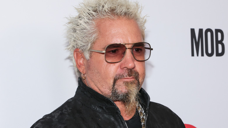 Guy Fieri at a movie event wearing sunglasses