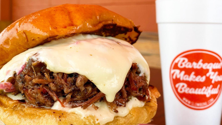 The Texas Nail sandwich with brisket, honey cheddar, smoked mushrooms, and caramelized onions, finished with roasted chiles, lime crema, and jalapeño BBQ sauce