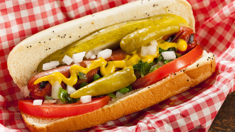 Close-up of Chicag-style hot dog served in red checkered paper