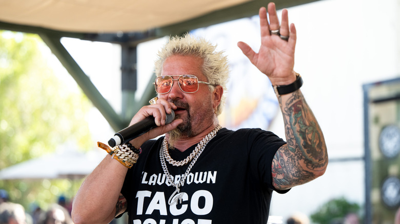 Chef Guy Fieri speaks on microphone at event