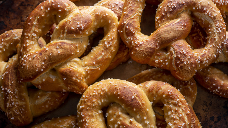 A pile of large salted pretzels resting on top of each other.