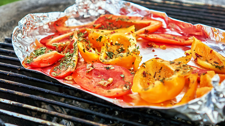 Vegetables cooking on aluminum foil on grill
