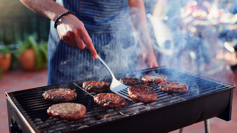 Man grilling burger patties