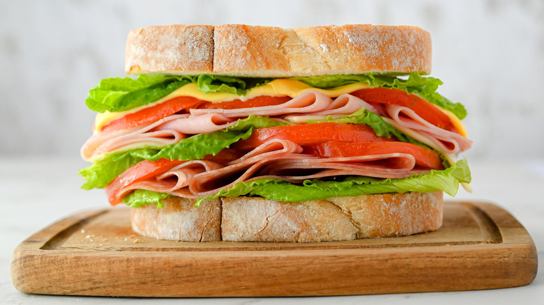 Sandwich with ham, turkey, cheese, lettuce, and tomato