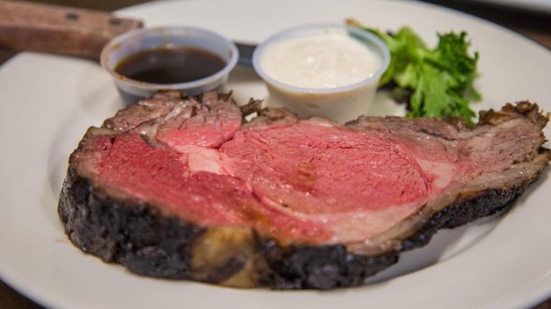 Slice of prime rib with au jus and creamy horseradish from Cotton's Restaurant.